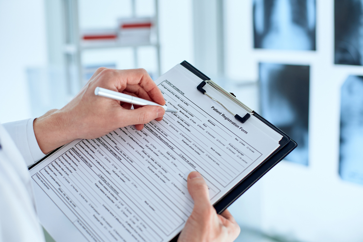 doctor is filling out the patient's registration form